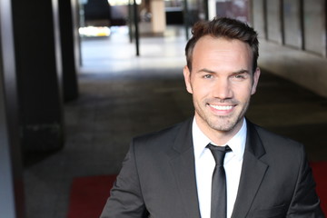 Fototapeta premium Smiley businessman walking outside the office building