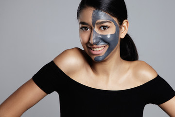 mixed race woman smiling with a half of face in mask