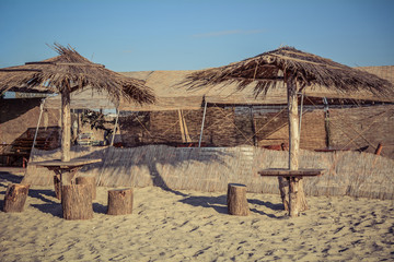 Two chairs and umbrella on a beach with shadow from palm tree