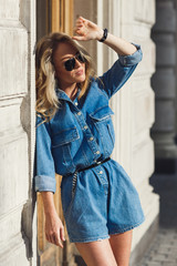 Street style. Beautiful woman walks on the street at the Moscow City at sunny spring day.