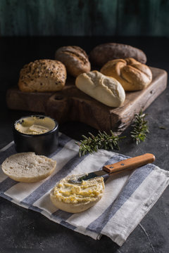 Different types of bread and butter on wooden background