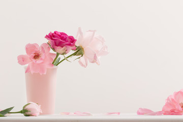 Fototapeta na wymiar Pink roses in vase on white background