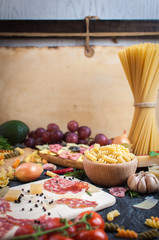 Pasta,  tomatoes, salami and cheese on the table