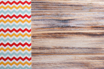 Obraz premium Colorful chevron tablecloth on wooden table