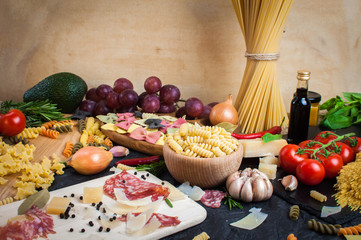 Pasta,  tomatoes, salami and cheese on the table