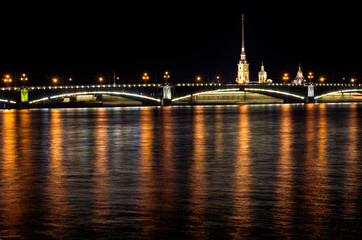 Night of St. Petersburg on the Neva, Peter and Paul fortress over the bridge and light reflections in the water