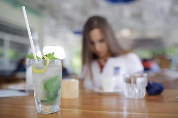 Woman having lunch in summer restaurant blurred background