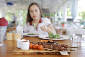 Obraz na płótnie Canvas Woman having lunch in summer restaurant blurred background