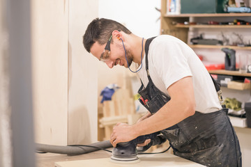 carpenter Using Electric Sander for wood