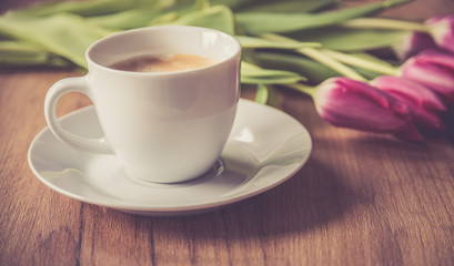  coffee cup with tulips on wooden back ground