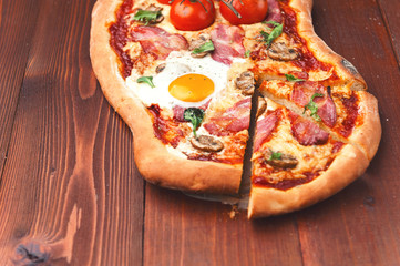 Fresh delicious pizza from the oven with egg, prosciutto and tomato