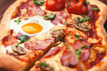 Fresh delicious pizza from the oven with egg, prosciutto and tomato