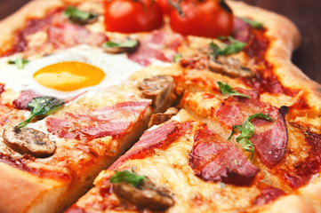 Fresh delicious pizza from the oven with egg, prosciutto and tomato