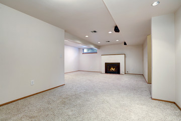 White empty basement room with fireplace