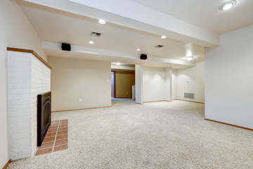 White empty basement room with fireplace