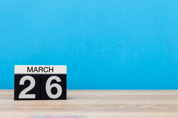 March 26th. Day 26 of month, calendar on table with blue background. Spring time, empty space for text