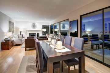 Grey tones dining space with glass doors to large upper deck