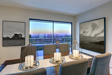 Grey tones dining space with glass doors to large upper deck