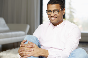 Relaxed young man portrait. Shot of an African American young man relaxing at home on the sofa while looking at camera and smiling.