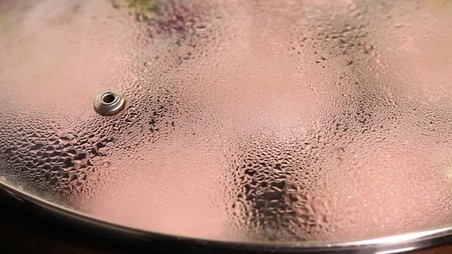 Droplets of moisture condense on glass pan cover Cooking