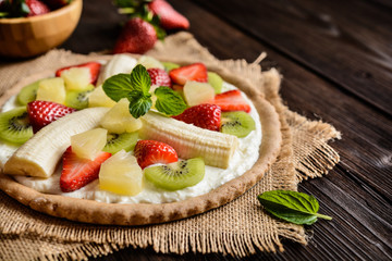 Fruit pizza with banana, kiwi, strawberry, pineapple