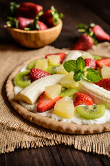 Fruit pizza with banana, kiwi, strawberry, pineapple
