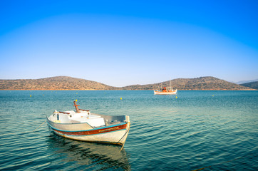 Fototapeta na wymiar Summertime Background. Traditional wooden fishing boat at Elounda, Crete, Greece.