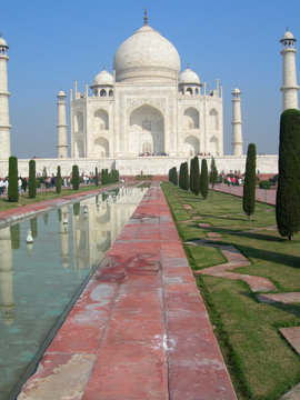 Side perspective of the Taj Mahal mausoleum in Agra, India, with the main building dome framed by the minaret towers and the reflection pool.