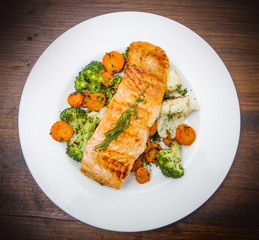 salmon fillet on a bed of broccoli, cauliflower and carrots