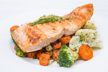 salmon fillet on a bed of broccoli, cauliflower and carrots