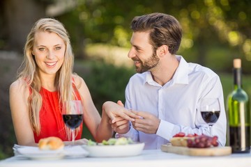 Man putting a ring on womans finger