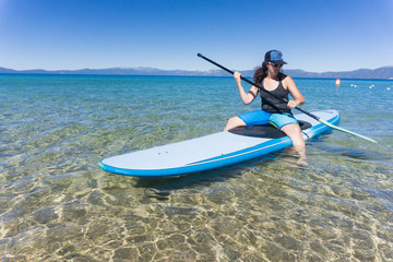 Young woman in hat and sunglasses enjoys watersports on a summer day at Lake Tahoe, California