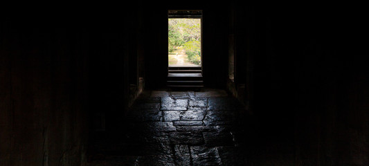 Fototapeta na wymiar Long corridor of pillars in temple ruins, Angkor Wat in Cambodia