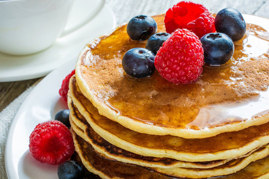 stack of pancakes with fresh berries and honey