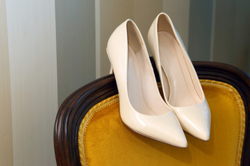 wedding shoes are on the back of the chair.