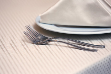 table setting forks on a table in the restaurant.