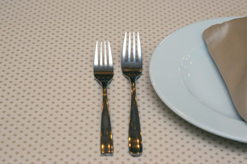 table setting forks on a table in the restaurant.