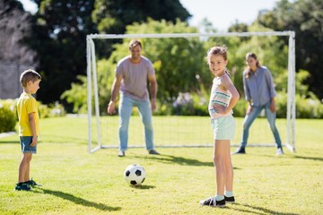 Family playing football together at the park