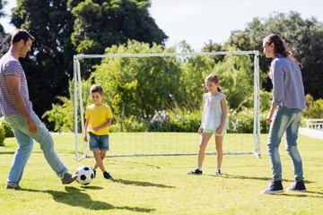 Obraz premium Family playing football together at the park