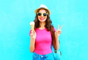 Fashion smiling young woman with ice cream over wearing straw hat colorful blue background