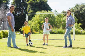 Obraz na płótnie Canvas Family playing football together at the park