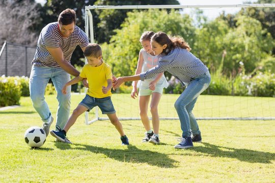 Family playing football together at the park