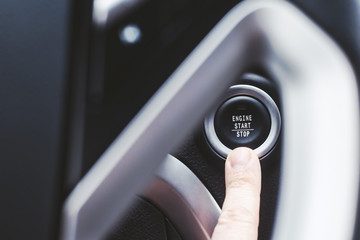 Engine start button and finger with shallow depth of field