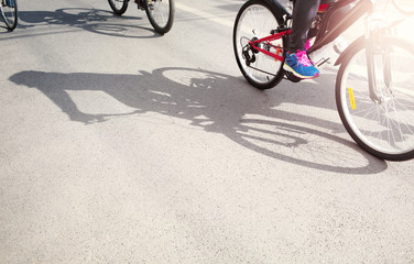 Fototapeta na wymiar Group of cyclist pedaling on a racing bike with hard shadow in a sunny day.