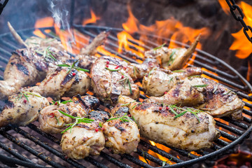 Hot chicken on grill with spices and rosemary