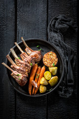 Tasty roasted lamb ribs on the burnt black table