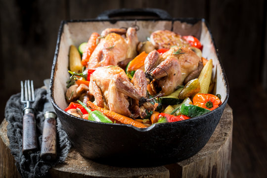 Wild quails with vegetables and spices in casserole