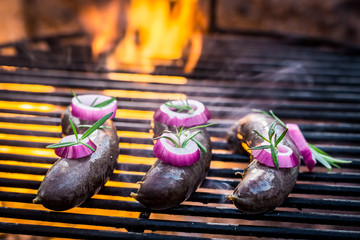 Black pudding with onion on the grill and fire