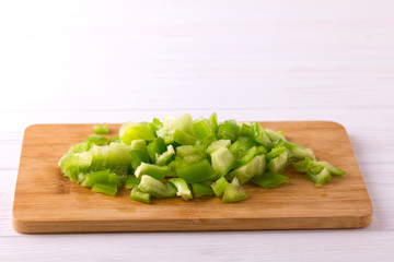 Chopped green bell pepper on wooden cutting board