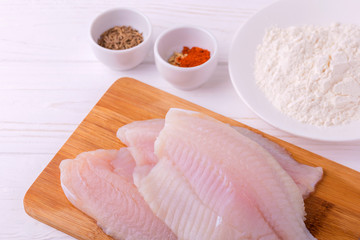 Ingridients for fried fish tilapia. Raw fillet, fleur, cumin